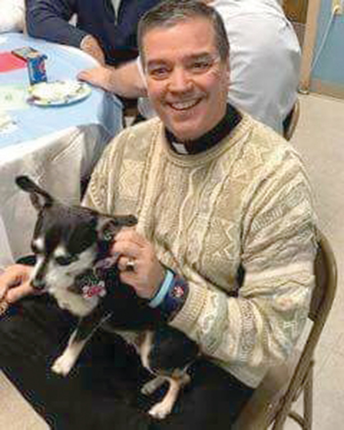 Father John Soares, the pastor at St. Thomas Church in Providence, smiles with his dog Dusty Rose. Father Soares has served St. Thomas Church and it’s school community for the past 11 years.